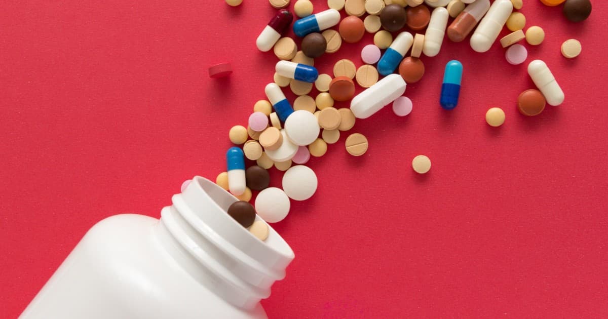 Bottle with pills and capsules of every color and size spilling out. The Cooper Complete team share common supplement misconceptions