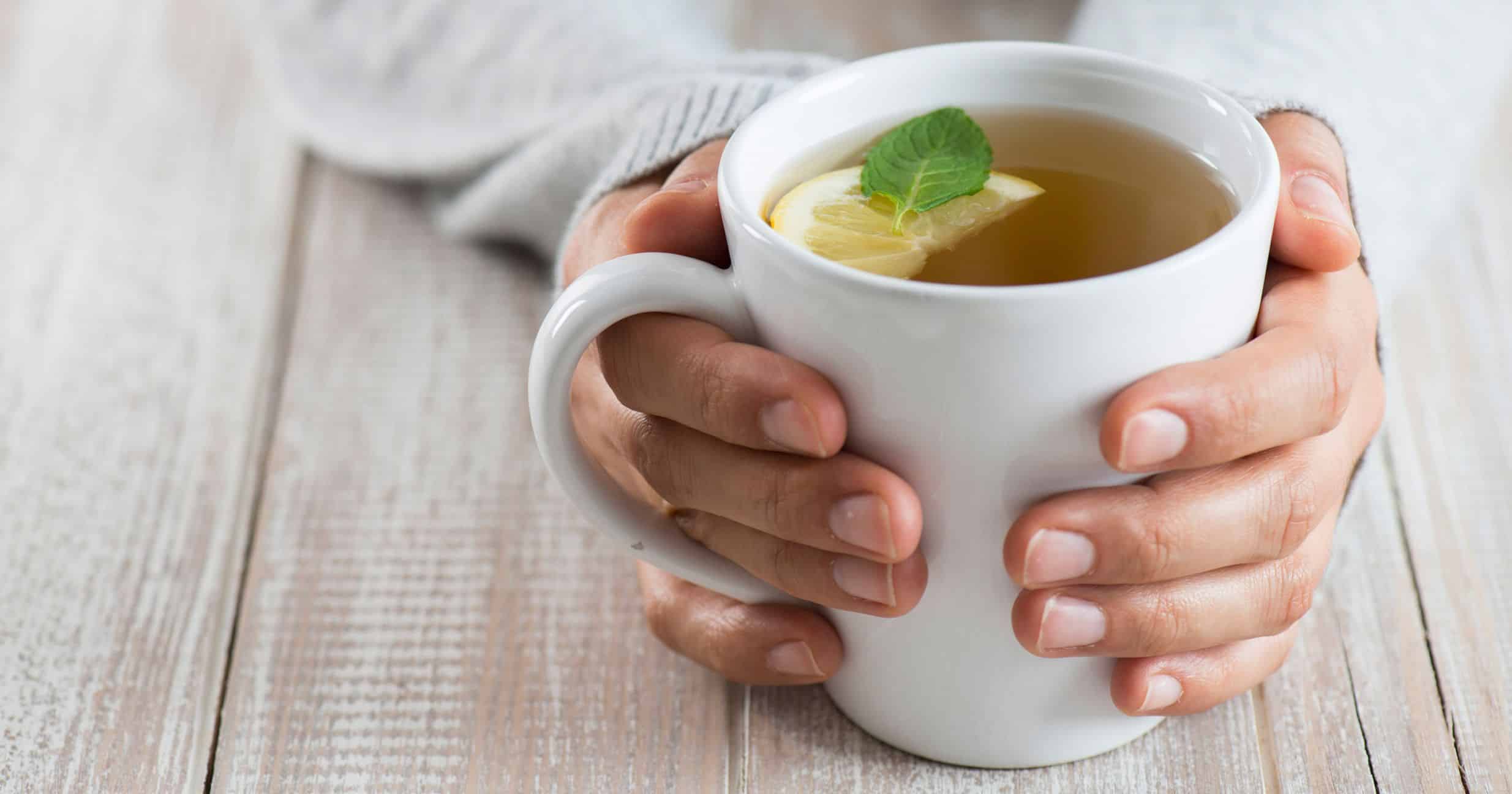 Cup of green tea being held