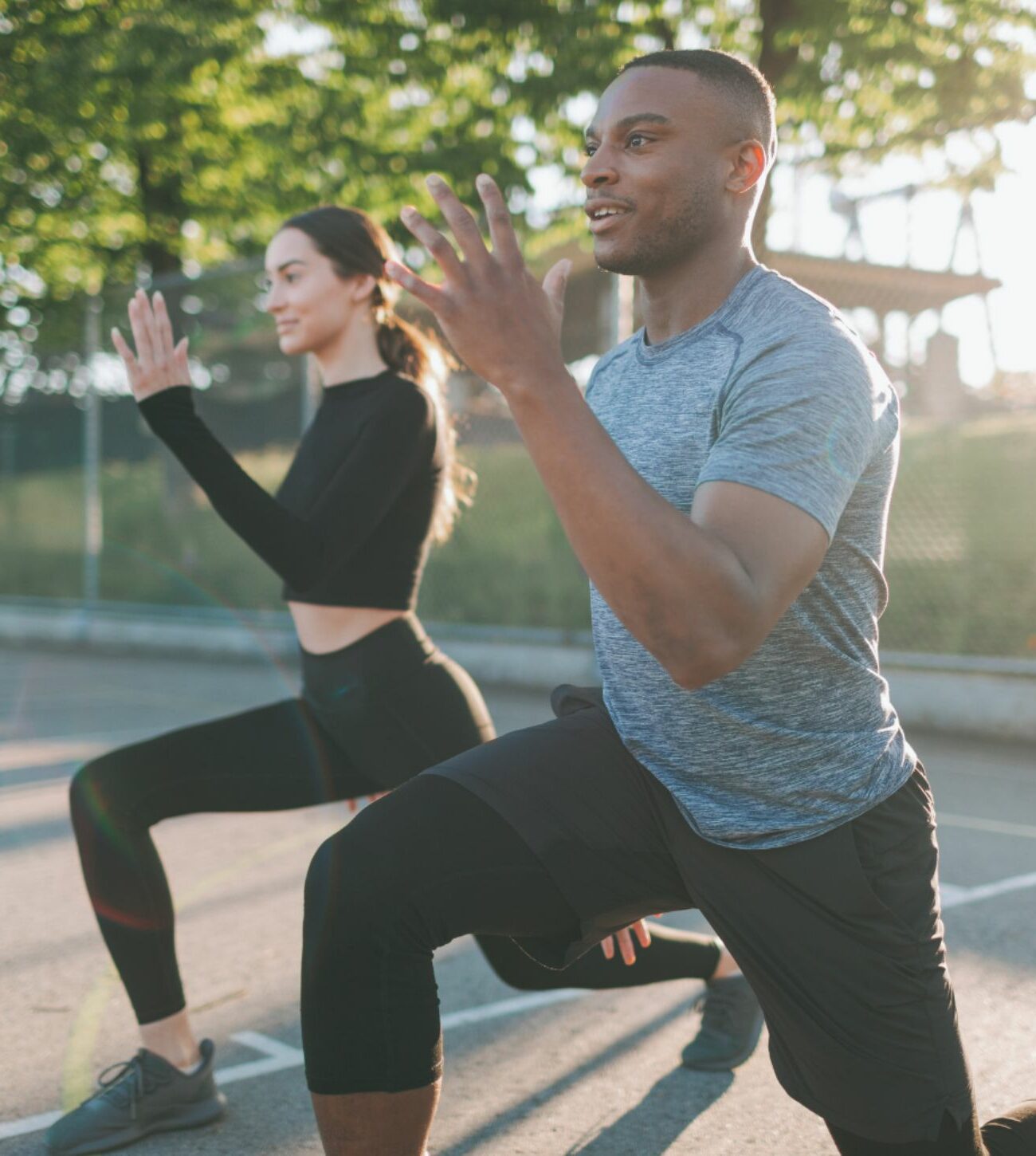 Photo of a multi-racial man and woman enjoying an outdoor workout.