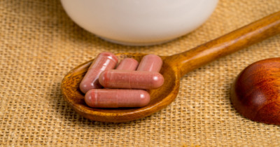 Photo of red yeast rice supplement pills on a wooden spoon