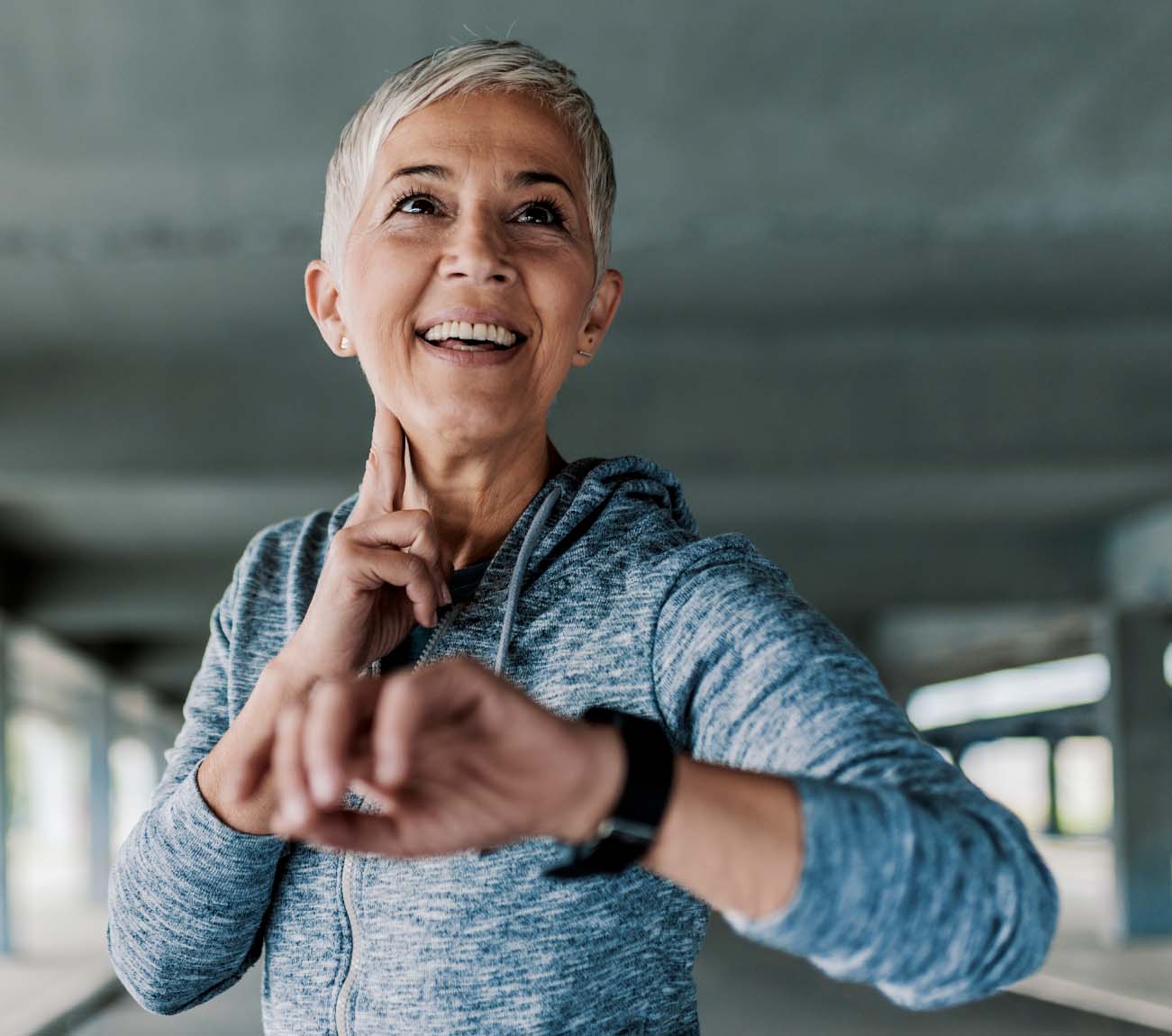 Photo of an attractive, older woman in her exercise gear checking her heart rate.