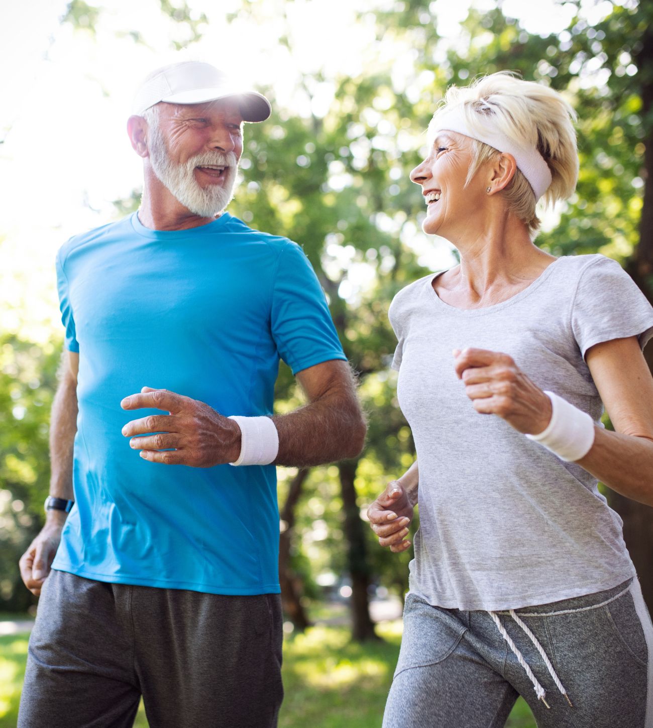 Photo of a mature man and woman flexing their muscles and joints on a morning walk or jog.