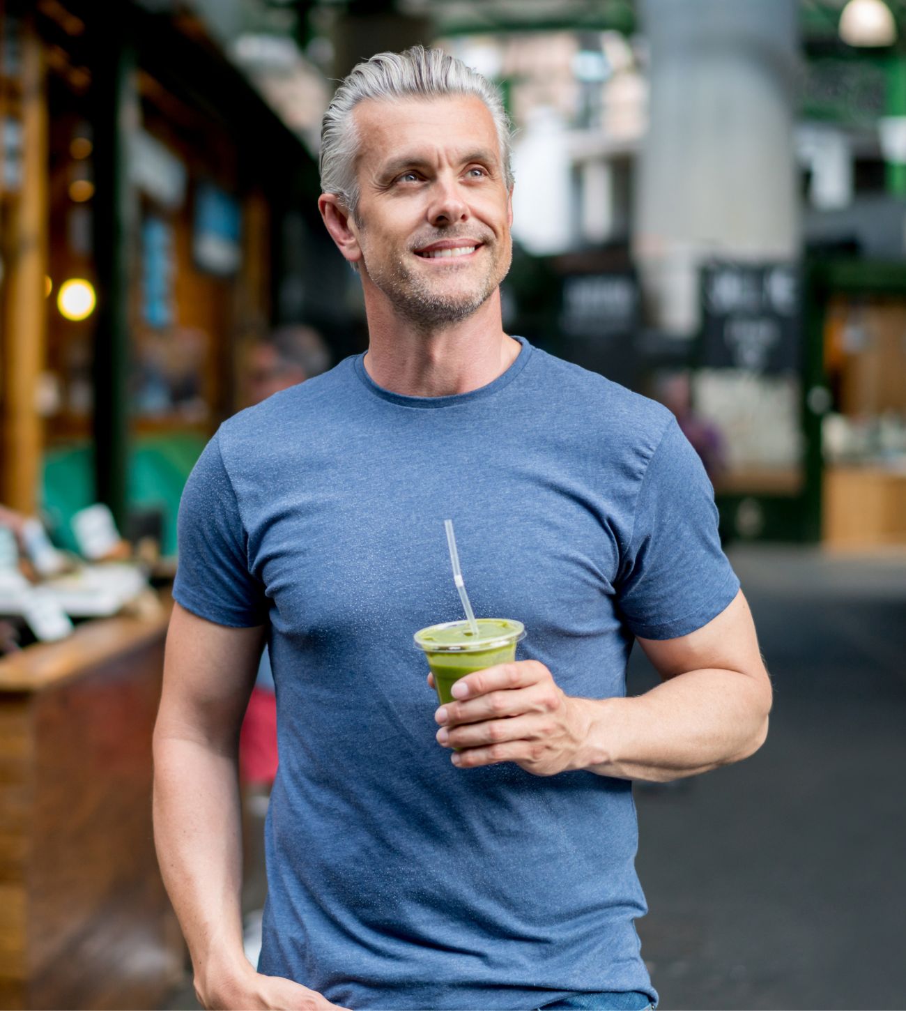 Photo of a man enjoying a green smoothie from a store.