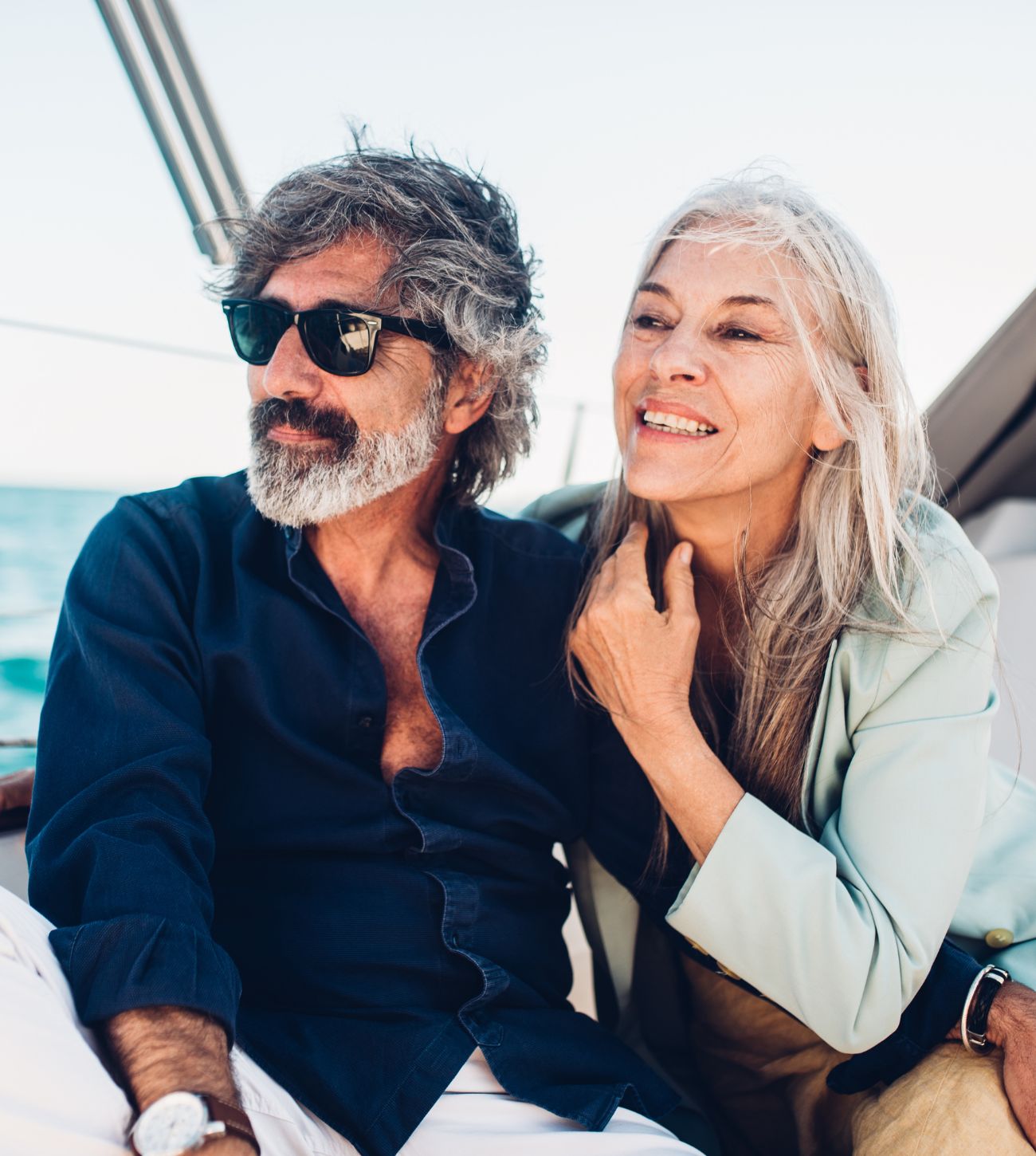 Photo of a mature man and woman enjoying a sunny, cooler afternoon sail.