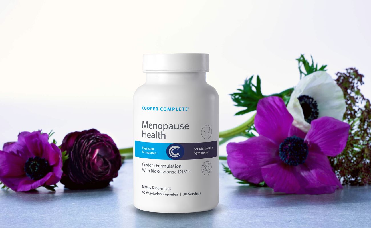 Photo of Cooper Complete Menopause Health Supplement bottle surrounded by beautiful flowers.