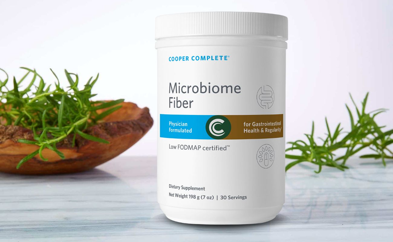 Photo of Cooper Complete Microbiome Fiber Supplement bottle on a marble counter with succulent plants and wood accents