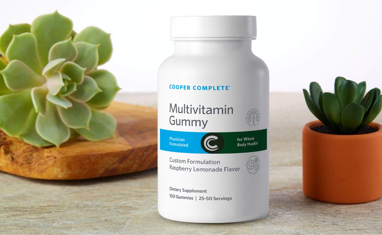 Photo of Cooper Complete Multivitamin Gummy Supplement bottle and succulent plants.