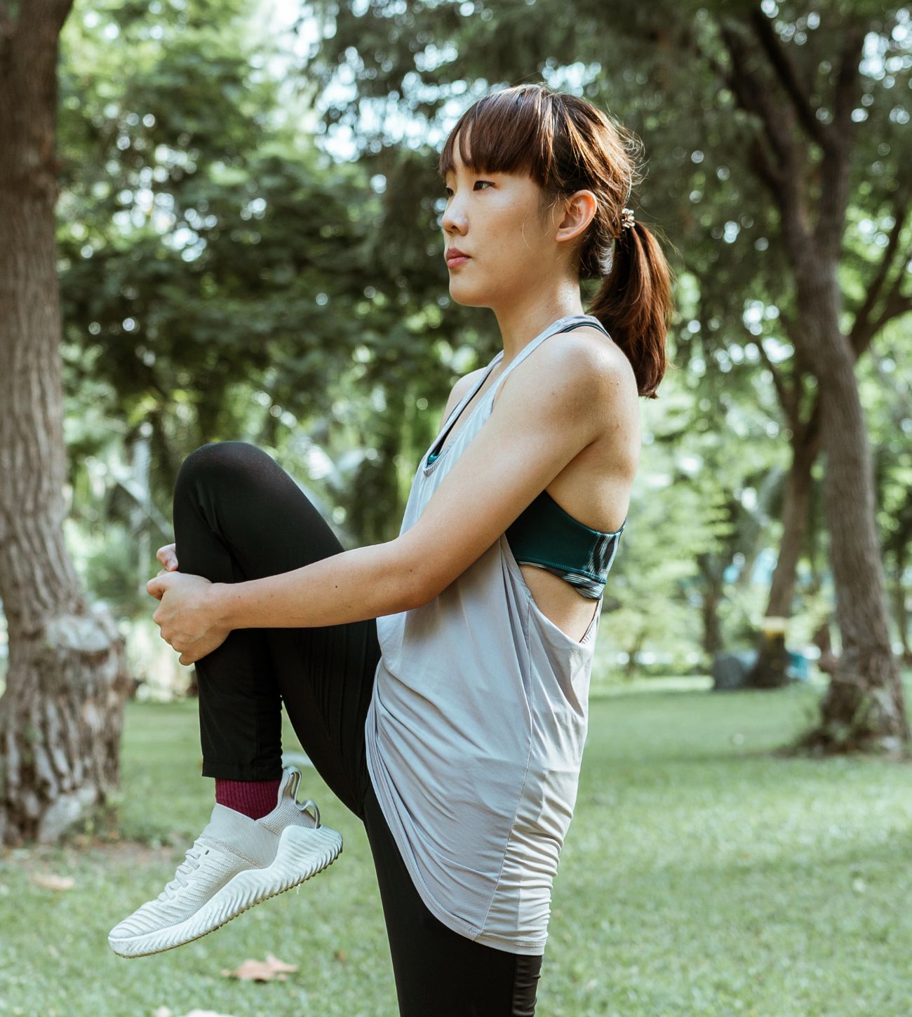 Photo of a young woman stretching in the park.