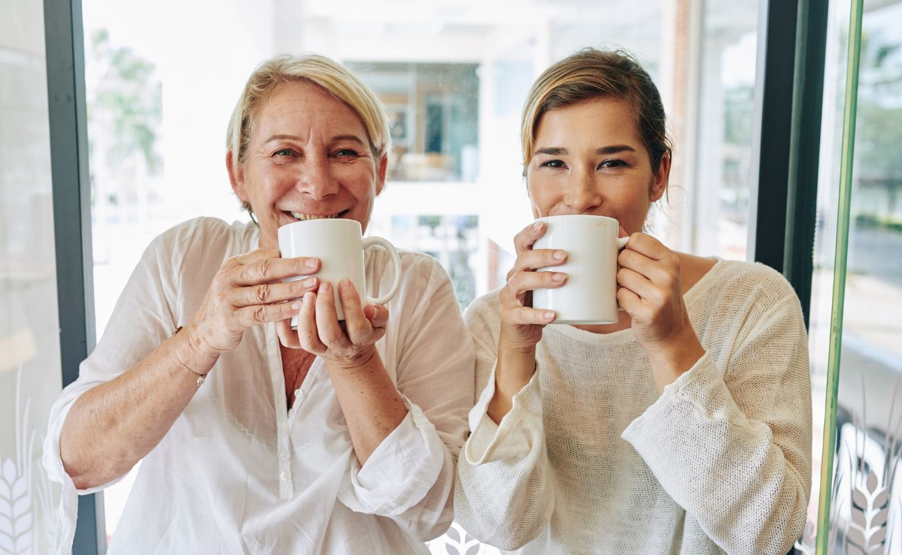 Photo of an older and younger woman enjoying tea together.