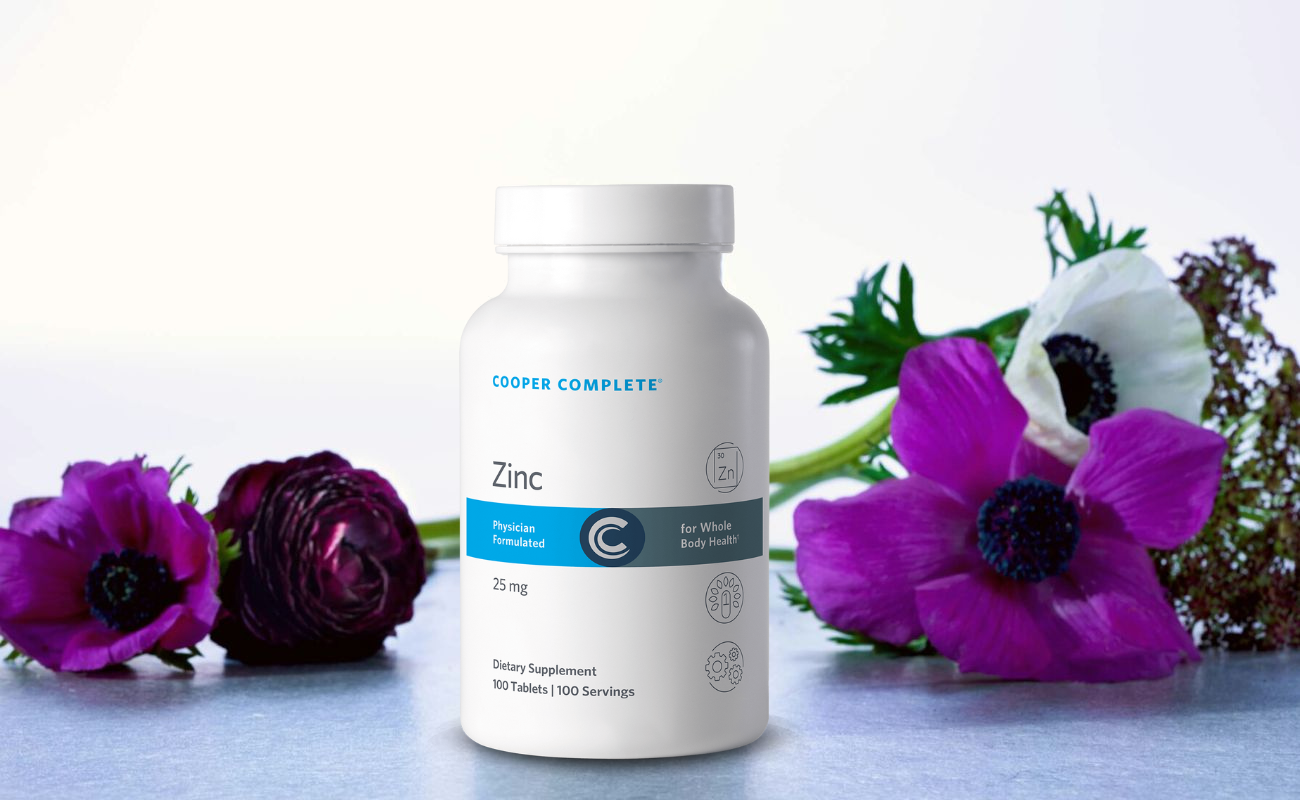 Photo of Cooper Complete Zinc Supplement on a counter with beautiful flowers.